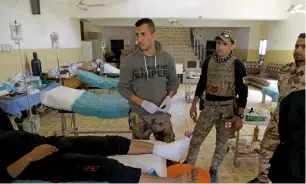  ?? AFP ?? Members of the Iraqi forces tend to a civilian at the school-turned hospital in Mosul. —