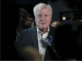  ??  ?? Horst Seehofer (center) chairman of Bavarian’s Christian Social Union party and German Interior Minister briefs the media after he leaves a board meeting of his party in Munich, early morning on Monday. SVEN HOPPE/DPA VIA AP