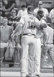  ?? WILFREDO LEE / ASSOCIATED PRESS ?? The Braves’ Chipper Jones hugs Jose Reyes of the Marlins, who gave the third baseman fly-fishing equipment as a retirement gift.