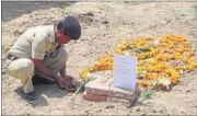  ?? VINAY SANTOSH KUMAR/HT ?? A police personnel lights a lamp at police horse Shaktiman’s grave in Police Lines, Dehradun, on Thursday.