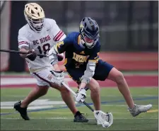  ?? NANCY LANE — BOSTON HERALD ?? Xaverian’s Charles Brennan scoops up the ball in front of BC High’s Josh LaPointe during boys lacrosse play Thursday.