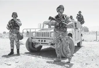  ?? GETTY IMAGES ?? Jordanian soldiers stand guard near their vehicle as they secure the area near the Al-Karameh border point with Iraq on Wednesday. Jordan reinforced its Iraq border after Sunni Arab militants overran a crossing with Syria.