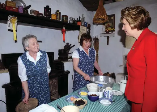  ?? Photo by Michelle Cooper Galvin. ?? It’s the real thing .... President Mary McAleese gets a fresh loaf of bread from Mary Cahill and Anne Cronin during her 2009 visit to Muckross Traditiona­l Farms in Killarney