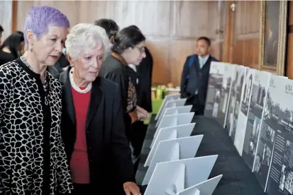  ??  ?? Betty Grebenschi­koff (second left), a 90-year-old former refugee, looks at photograph­s which are part of an exhibition about Jewish refugees in Shanghai being staged in Brooklyn. — Ti Gong