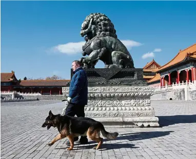  ??  ?? 24/7: Security staff of canine patrol squad Zhang Yu and a guard dog patrol at the Forbidden City in central Beijing, China. — Reuters