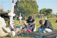  ?? CAROLYN COLE/TRIBUNE NEW SERVICE ?? Mourners gather to remember those who were killed in the shooting at Marjory Stoneman Douglas High School last month.