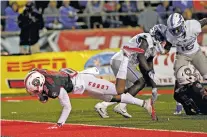  ?? ANDRES LEIGHTON/ASSOCIATED PRESS FILE PHOTO ?? UNM wide receiver Delane Hart-Johnson dives into the end zone past Air Force defensive backs Robert Bullard and Marquis Griffin last month in Albuquerqu­e. The trio of Hart-Johnson, Jay Griffin IV and Chris Davis has developed into a threat for the...