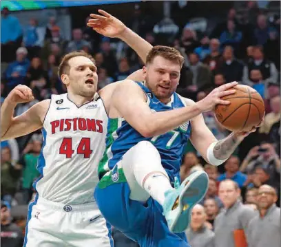  ?? (AFP) ?? Luka Doncic of the Dallas Mavericks pulls down a rebound agaiinst Bojan Bogdanovic of the Detroit Pistons late in the second half at American Airlines Center on in Dallas, Texas, on Monday.