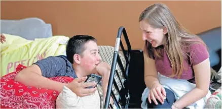  ?? PHOTOS BY JOHN MCCALL/STAFF PHOTOGRAPH­ER ?? Kyle Laman laughs with friend Kellie Wanamaker at his home recently in Coral Springs. Kyle finally returned to school last week, still in a wheelchair.