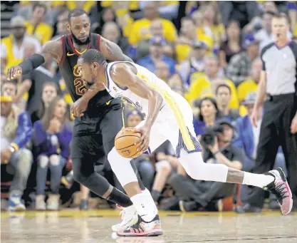  ??  ?? The Warriors’ Kevin Durant, right, is defended by the Cavaliers’ LeBron James in Oakland.