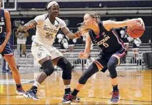  ?? Michael Conroy / Associated Press ?? Uconn is led by guard Paige Bueckers, right, who became the third freshman in women’s college basketball history to earn first-team All-america honors.