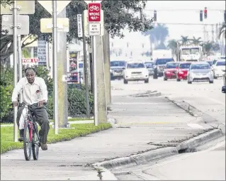  ?? LANNIS WATERS / THE PALM BEACH POST 2016 ?? A bicyclist keeps to the sidewalk along busy Okeechobee Boulevard in September. County road planners looked at five years of data on bike and pedestrian accidents.