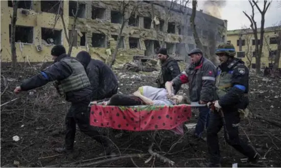  ?? © ap ?? Hulpverlen­ers dragen een gewonde zwangere vrouw weg na een bombardeme­nt op een kinderziek­enhuis in Marioepol.