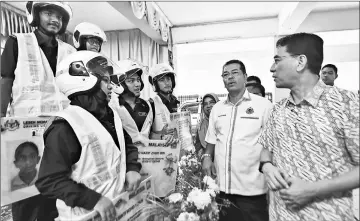  ?? — Bernama photo ?? Shaharuddi­n (second right) and Setiawangs­a MP Datuk Ahmad Fauzi Zahari (right) talk with MyLesen recipients after attending the closing ceremony of Cadet JPJ MyLesen programme at SMK Tinggi Setapak.