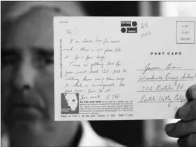  ??  ?? James Grein, 61, at his house in Sterling, Va., on July 26, holds a Florida postcard sent to him when he was 15 years old by now-defrocked Cardinal Theodore McCarrick. AP PHOTO/MANUEL BALCE CENETA