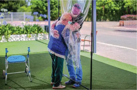  ?? EFE/BIEL ALIÑO ?? Una interna de una residencia abraza por primera vez en tres meses a su hijo a través de un plástico