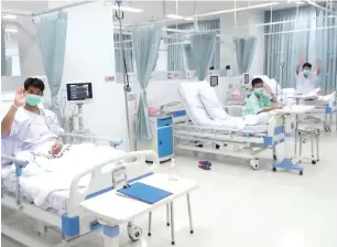  ?? AFP ?? This video grab taken from an undated footage shows rescued football team coach Ekkapol Chantawong (left) with two members of the team at the hospital in Chiang Rai province. —