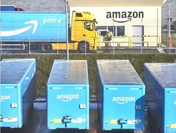  ??  ?? A truck pulling an Amazon Prime branded cargo container waits beside the entrance gate at Amazon.com Inc.’s new fulfilment centre in Kolbaskowo, Poland, in Feburary.