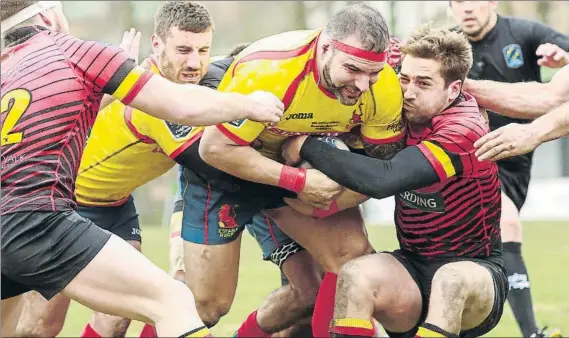  ?? FOTO: EFE ?? Fernando Pérez es placado por la defensa belga ante la mirada del árbitro rumano Vlad Iordachesc­u, muy protestado por los españoles. La derrota de los ‘Leones’ clasificó a Rumanía