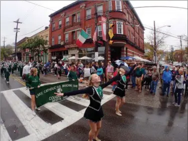  ?? JONATHAN TRESSLER — THE NEWS-HERALD ?? Two majorettes from the Lake Catholic Cougars Marching Band are about to catch their batons as the band plays on and the flag corps brings up the rear during the 2017 Columbus Day Parade in Little Italy on Oct. 9.