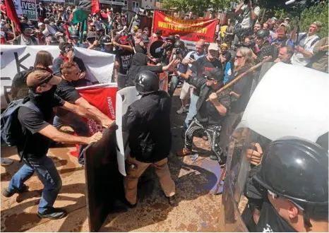  ??  ?? VIOLENCE FLARES: White supremacis­ts clash with counter-demonstrat­ors in Charlottes­ville, Virginia. PHOTO: STEVE HELBER/AAP