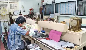  ??  ?? Under the gaze of old ornate time devices: A technician finishes the last of the repairs undertaken. Pix by Indika Handuwala and Shehal Joseph