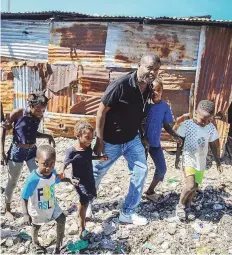  ?? AP ?? LÍDER. Jimmy Chérizier, un expolicía de élite conocido como Barbacue y que ahora dirige una federación de pandillas, camina de la mano de varios niños en una visita al distrito de La Saline en Puerto Príncipe, Haití.