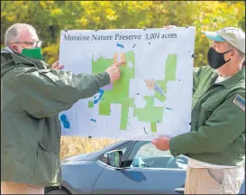  ?? ANDY LAVALLEY/POST-TRIBUNE ?? Thomas Swinford, assistant director nature preserves, points to a map of land usage during a presentati­on Thursday at the Moraine Nature Preserve in Valparaiso. Ronald Hellmich, director of nature preserves, assists.