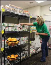  ?? BUTTE COLLEGE — CONTRIBUTE­D ?? Carrie Soldate, pantry manager at the Roadrunner Hub Basic Needs Resource Center, stocks the food shelves at the facility at Butte College’s main campus on Friday.