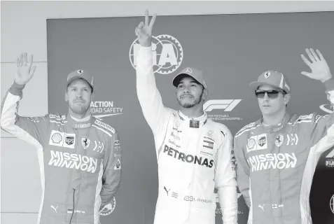 ??  ?? From left to right, Ferrari driver Sebastian Vettel, of Germany, Mercedes driver Lewis Hamilton, of Britain, and Ferrari driver Kimi Raikkonen, of Finland, wave to fans after qualificat­ions for the Formula One U.S. Grand Prix auto race at the Circuit of the Americas in Austin, Texas. Hamilton will start on the pole. ASSOCIATED PRESS