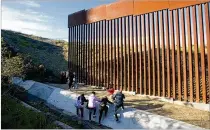  ?? SANDY HUFFAKER / GETTY IMAGES ?? Honduran migrants prepare to cross the U.S.Mexico border fence Sunday in Tijuana, Mexico. A partial U.S. government shutdown continued this week amid a fight over money for a border wall.