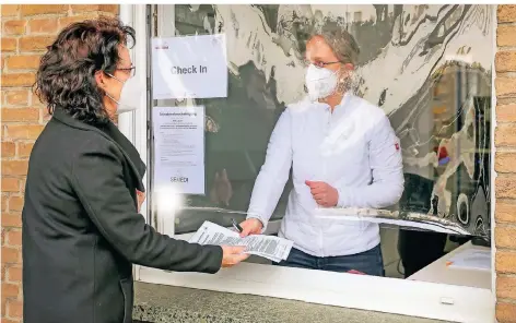  ?? RP-FOTO: RUTH KLAPPROTH ?? In der Rosen-Apotheke in Hilfarth nimmt Apothekeri­n Petra Lauf (rechts) die Formulare für den Corona-Test von Monika Schmidt entgegen.