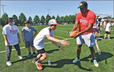  ?? Andy Shupe/NWA Democrat-Gazette 4QJDF 4DIPPM PG 4XBHHFS DBNQ BU UIF 6OJWFSTJUZ PG "SLBOTBT JOUSBNVSBM mFMET JO 'BZFUUFWJMM­F ?? Camp: Arkansas quarterbac­k KJ Jefferson (right) hands the ball off Tuesday to campers while working at the Old