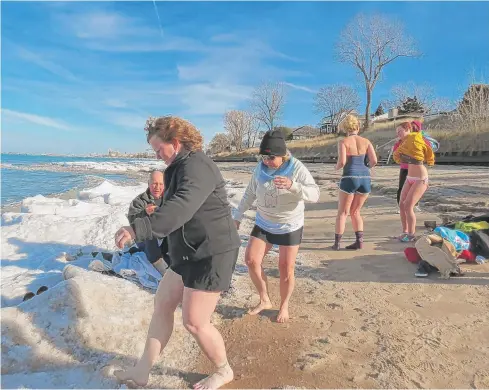  ?? | PHOTO PROVIDED BY KATIE MYSLIWIEC ?? Participan­ts step over the ice Thursday to take part in the polar bear plunge in Lake Michigan at Ogden Dunes.