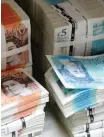  ?? Reuters ?? Piles of British Pound Sterling banknotes are stacked in the image.