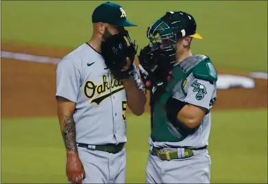  ?? TONY GUTIERREZ — THE ASSOCIATED PRESS ?? The Athletics’ Mike Fiers, left, is paid a visit on the mound by catcher Sean Murphy during the fourth inning of Wednesday’s game.