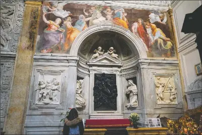  ??  ?? A woman admires the 1514 fresco “Sybils receiving instructio­n from Angels” by Italian High Renaissanc­e master painter Raffaello Sanzio, known as Raphael, inside of Santa Maria della Pace church in Rome.
(AP/Andrew Medichini)