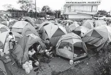  ?? Tribune News Service file photo ?? Migrants from Central America and Mexico wait in a tent encampment in 2019 at the U.S.-Mexico border.