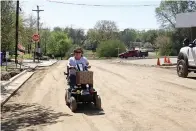  ?? (Photo by Neil Abeles) ?? Lisa Gore is especially happy to be out on Kaufman Street in Linden which is getting a new road surfacing. “I travel this way daily, and I can do everything and go everywhere I want with my cart. It will be easier when paved. I’m happy,” Gore said.