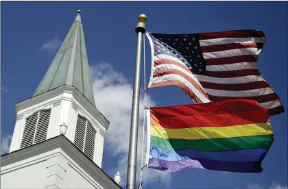  ?? CHARLIE RIEDEL — THE ASSOCIATED PRESS ?? A gay pride rainbow flag flies along with the U.S. flag in front of the Asbury United Methodist Church in Prairie Village, Kan., in 2019. Conservati­ve leaders within the United Methodist Church seek to form a new denominati­on, the Global Methodist Church.