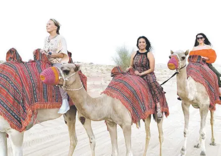  ?? — Bree McCool photo ?? Women ride camels in Dubai during a trip organized by Fit & Fly.