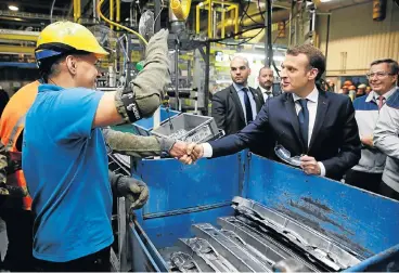  ?? /Reuters ?? Economic boost: French President Emmanuel Macron greets workers as he visits Toyota’s vehicle manufactur­ing plant at Onnaing, France, on Monday. The Japanese company’s expansion plans for the factory are expected to create 700 new jobs.