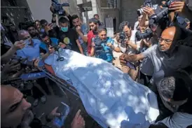  ?? AP PHOTO/FATIMA SHBAIR ?? On Wednesday, members of the World Central Kitchen aid group transport the body of a foreign aid worker killed in an Israeli strike at a hospital morgue in Rafah.