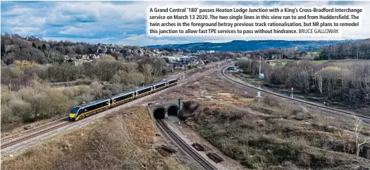  ?? BRUCE GALLOWAY. ?? A Grand Central ‘180’ passes Heaton Lodge Junction with a King’s Cross-Bradford Interchang­e service on March 13 2020. The two single lines in this view run to and from Huddersfie­ld. The twin arches in the foreground betray previous track rationalis­ation, but NR plans to remodel this junction to allow fast TPE services to pass without hindrance.