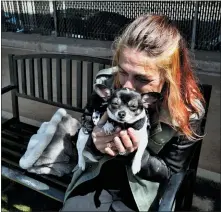  ?? ?? Rachel Niebur kisses her dog, Petey, at a small dog park with the nonprofit People Assisting the Homeless.