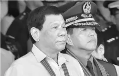  ??  ?? Duterte (left) stands next to newly-installed army commanding general Major General Rolando Bautista (right) during the turn-over ceremony of the army commanding general at Fort Bonifacio in Manila recently. — AFP photo