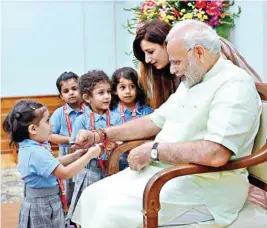  ?? PTI ?? Children ties rakhi on PM Narendra Modi on the occasion of Raksha Bandhan festival, in Delhi on Sunday