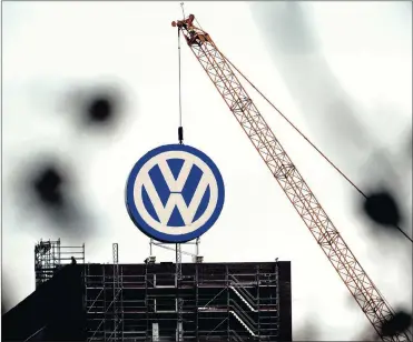  ?? FILE PHOTO: EPA ?? Constructi­on work and a crane over the VW logo on the administra­tive building of the Volkswagen factory in Wolfsburg, Germany. The German firm made a record group operating profit last year, excluding one-off items.