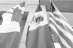  ??  ?? This file photo shows the Mexican, US and Canadian flags in the lobby where the third round of the NAFTA renegotiat­ions took place in Ottawa, Ontario. — AFP photo