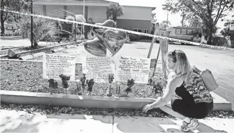  ?? PHOTOS BY CARLINE JEAN, SOUTH FLORIDA SUN-SENTINEL, VIA AP ?? Janice Connelly sets up a makeshift memorial to the eight who died in the heat at The Rehabilita­tion Center at Hollywood Hills, Fla.